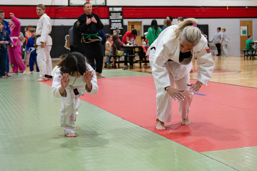 An instructor from Harai Dojo in Yelm helps a student practice a judo move during the Tenino Japanese Festival at Tenino High School on Saturday, May 12.