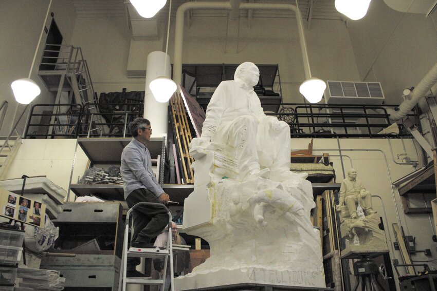 Haiying Wu observes the details of the 9-foot Billy Frank Jr. styrofoam statue from an angle at South Puget Sound Community College's Scene Shop on May 2.