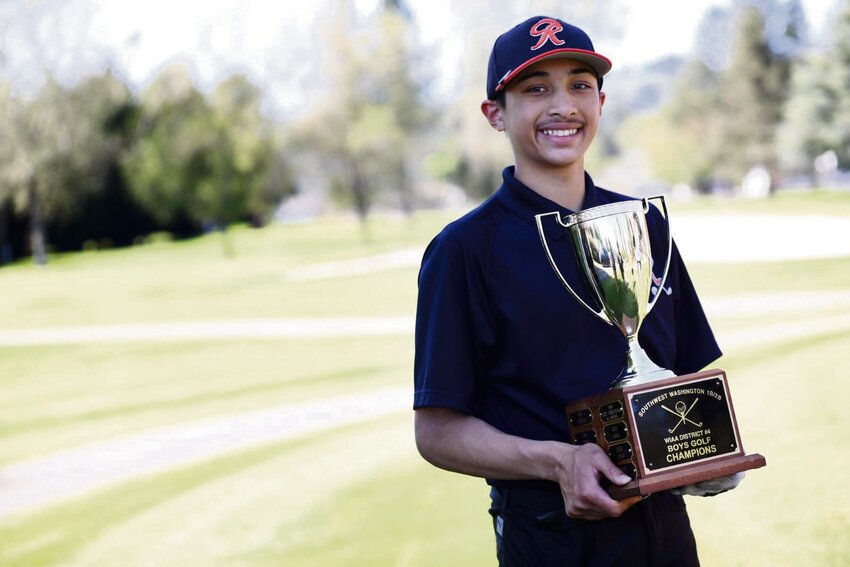 Rainier freshman golfer Joshua Peralta poses for a photo with the 2B District 4 champion trophy on May 9 at Mint Valley Golf Course in Longview.