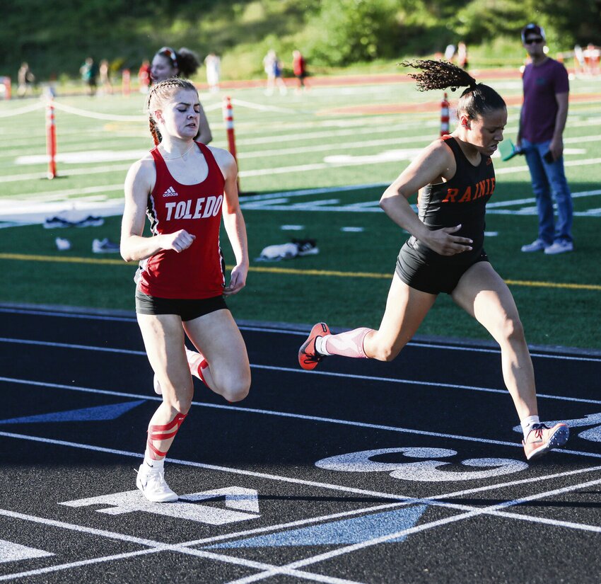Rainier's Jazzlyn Shumate (right) leans across the finish line to beat Toledo's Onica Chase in the 400-meter dash during the Central 2B League Championships on Friday at Chinook Stadium in Kalama.