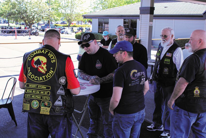 Members of the Combat Veterans Motorcycle Association receive stamps on their poker cards for the Thank a Veteran Ride at 507 Taproom & Filling Station on May 11.