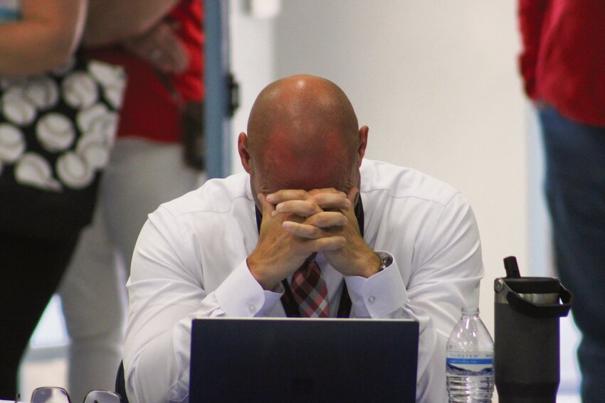 Yelm Community Schools Superintendent Chris Woods puts his head into his hands after the school board unanimously approved a reduced education plan on May 9.