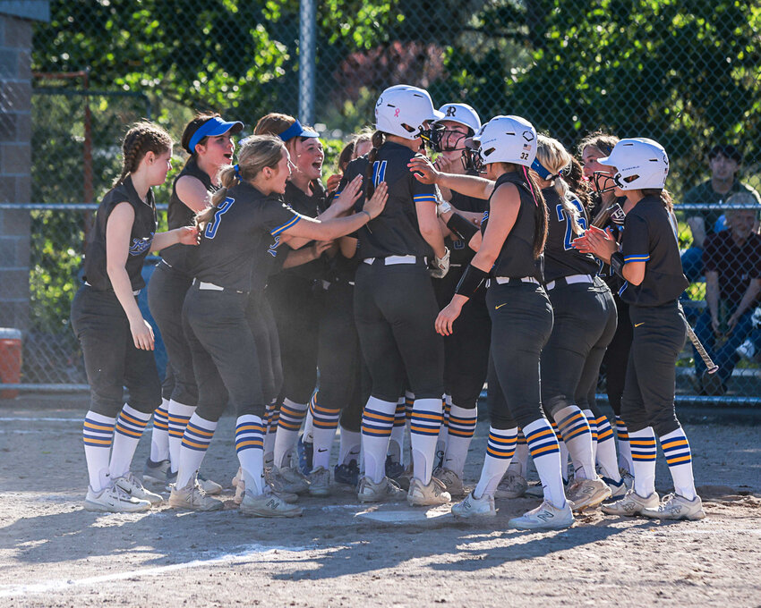 The Warriors greet Leah Hartley at home plate after Hartley hit a three-run home run during Rochester's 18-0 win over Hockinson in the 2A District 4 pigtail game in Hockinson on May 14.