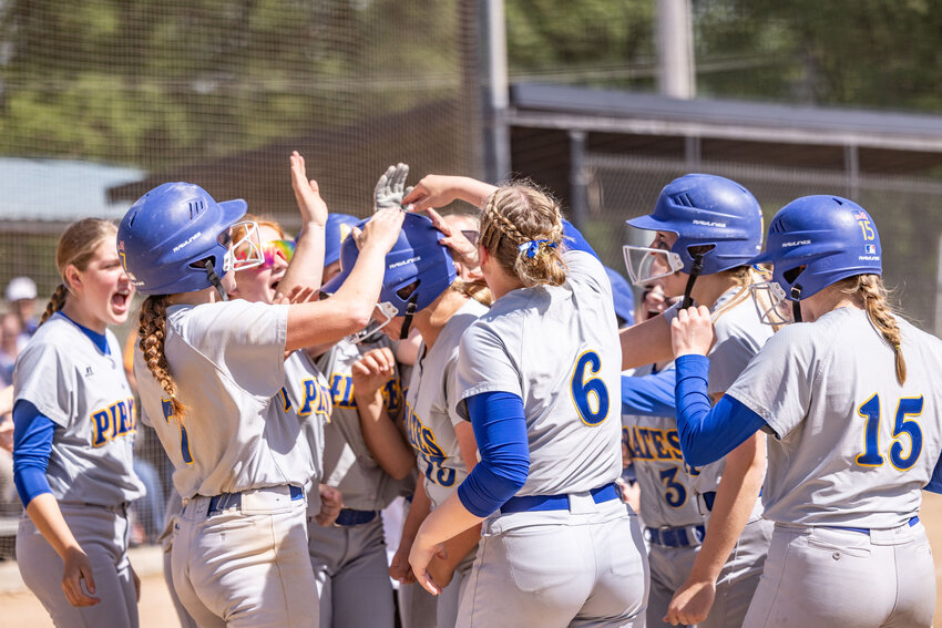 Adna teammates celebrate with Adna&rsquo;s Ava Simms after a home run during a high school softball game at Fort Borst Park on Wednesday, May 15.
