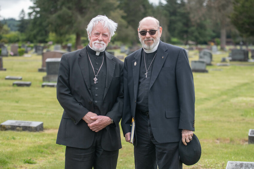 Father Gary Graveline, Sr., left, and Stephen Morrison pose for a portrait at Mountain View Cemetery in Centralia on Thursday, May 16.