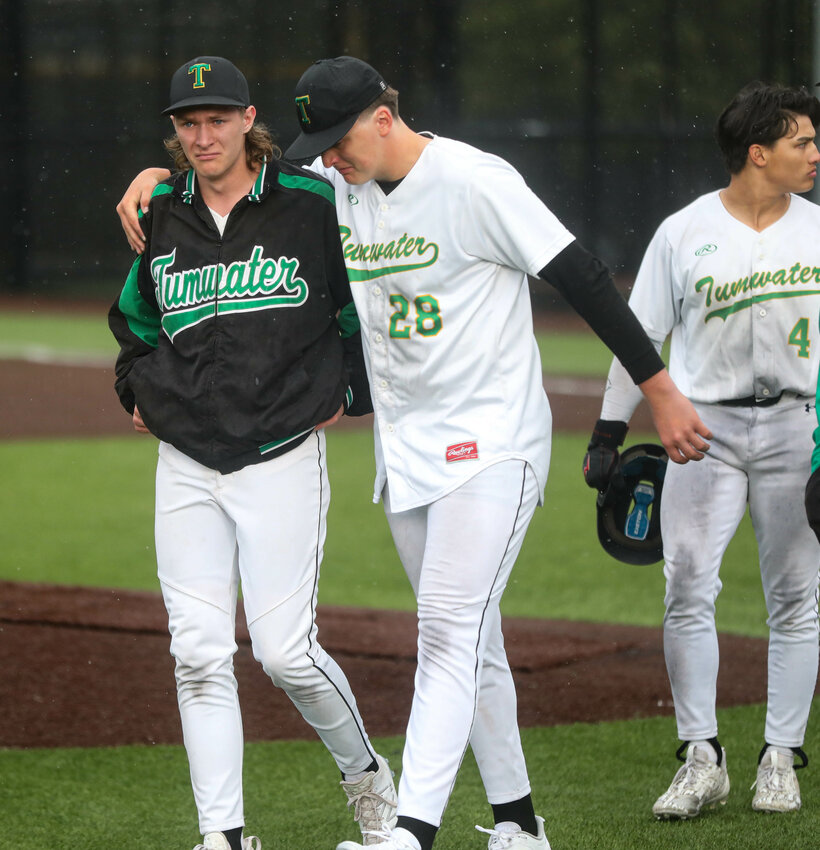 Tumwater's Braeden Konrad (28) wraps his arm around the shoulders of Liam Karlson after losing to Enumclaw 9-8 in a Class 2A state quarterfinal baseball game on Saturday at Auburn High School.
