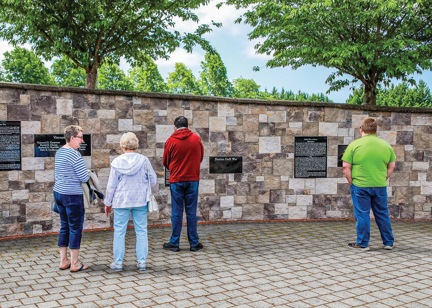 Attendees of a Memorial Day ceremony pay their respects to fallen service members at the Battle Ground Veterans Memorial in Kiwanis Park at last year’s ceremony.