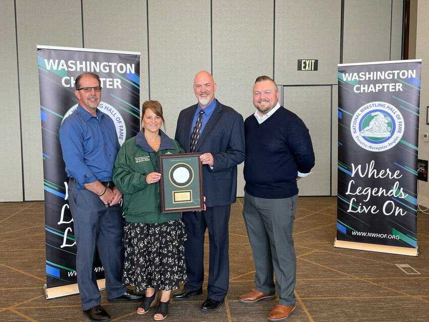 Gary Warnock, Chris Warnock, Chris Holterman and Steve Fittinger pose for a photo with Sgt. Justin Norton's green jacket and Medal of Courage at the Washington Chapter of the National Wrestling Hall of Fame induction banquet on May 4.