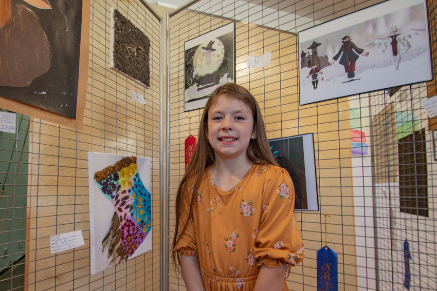 Homeschool student Aliya Penner of Morton stands next to the two mixed-medium art pieces using wildflowers, bark and dissected owl pellets on Friday, May 31, after she submitted for the local Lewis County high school students art show at the BCJ Gallery in Morton. Students from the White Pass, Morton, Mossyrock, Onalaska and Napavine high schools, along with some East Lewis County home school students, had their work displayed this past weekend at the BCJ Gallery in Morton, located at 231 W. Main Ave. The art show was organized by BCJ Gallery volunteer Cecelia Callison and was meant to highlight the artistic talents of students in those areas.&rdquo;