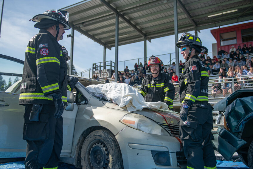 Lewis County Fire District 2 first responders and the Washington State Patrol act out a collision response during a mock crash, funeral, and trial at a distracted driving awareness event at Toledo High School on Friday, May 31.