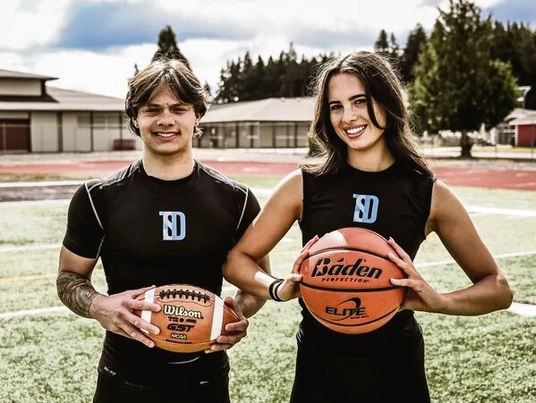 Total Sports Development NIL brand ambassadors Kyler Ronquillo and Henlee Sherman pose on Yelm High School&rsquo;s turf field.