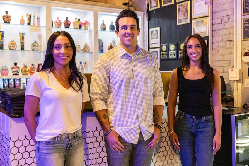 Co-owner Trent Breland, middle, Savanna Bolivar, right, and Sage Bolivar pose for a photo at Central Park Tanning and Wellness, rebranding to Luminous Lounge, in Centralia on Thursday, June 6.