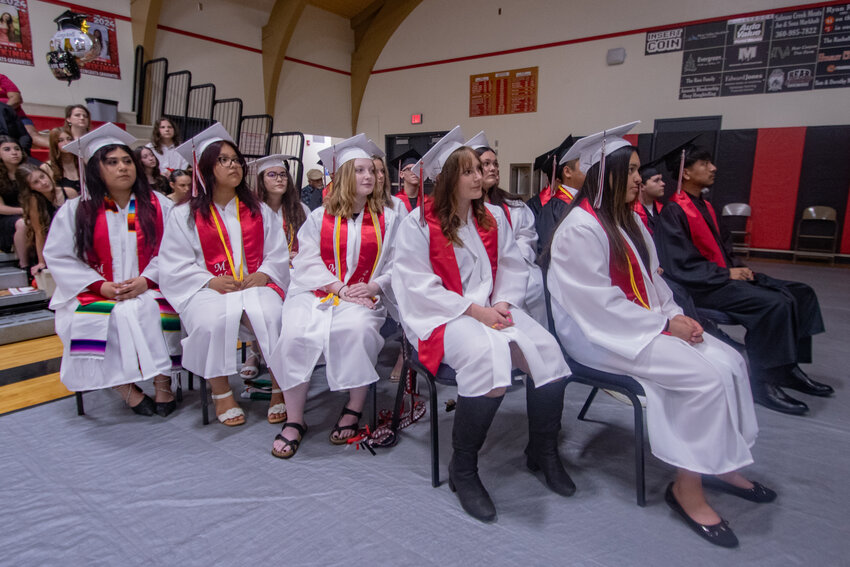 Part of the Mossyrock High School 2024 senior class watches as photos from their childhoods are displayed during their graduation ceremony at the high school on Saturday, June 8.
