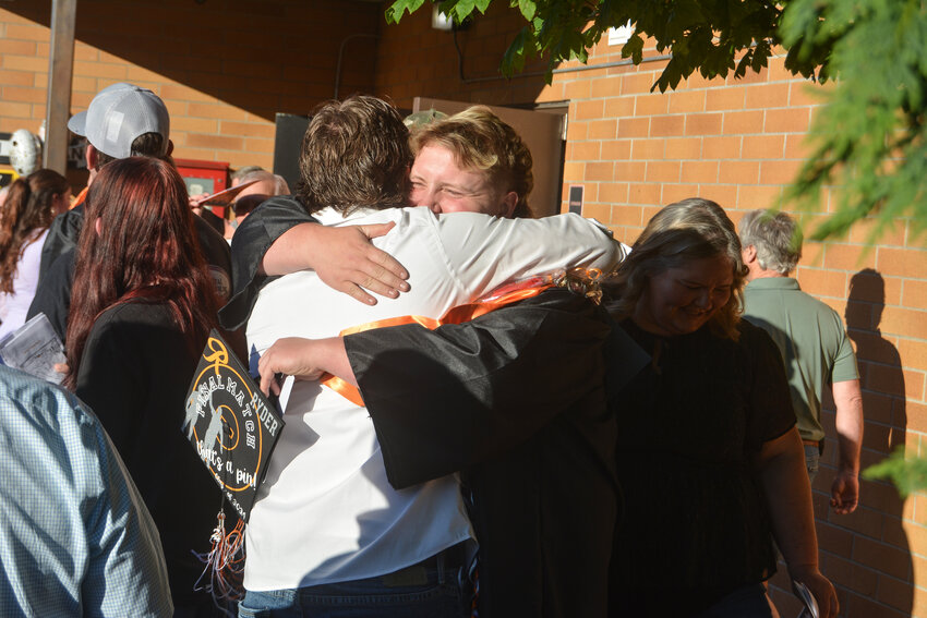 Ryder Cruse hugs his brother, Ricky, after Rainier High School's Class of 2024 graduation on Friday, June 7.