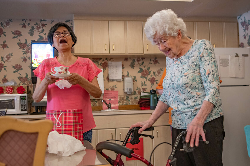 &ldquo;So she can invite us over for tea,&rdquo; Helaine Gallanger announces as she gifts May Douglas, left, with a tea cup at Douglas&rsquo; retirement party inside Sharon Care Senior Living Center in Centralia on Friday, June 7.
