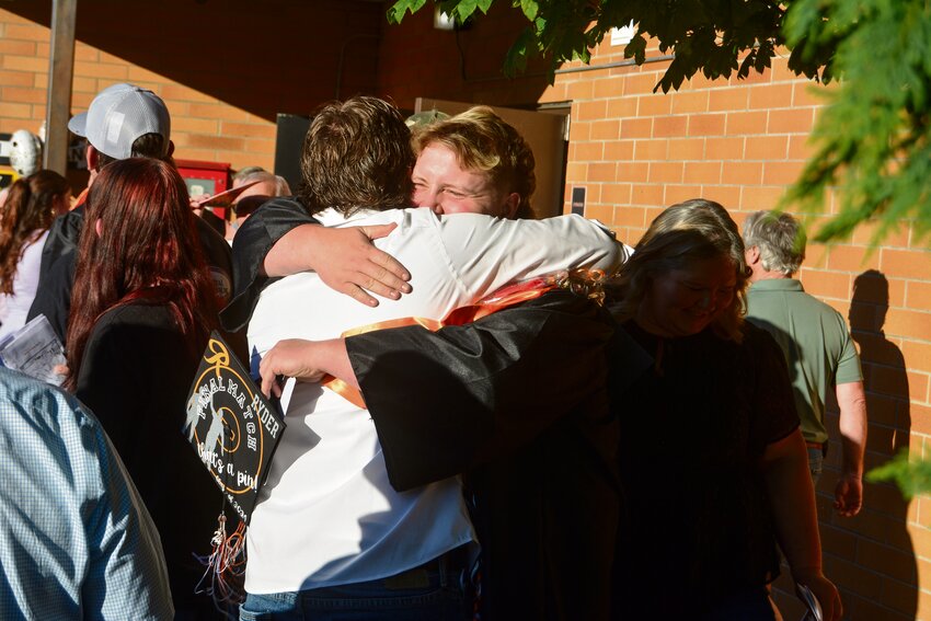 Ryder Cruse hugs his brother, Ricky, after Rainier High School's class of 2024 graduation on Friday, June 7.