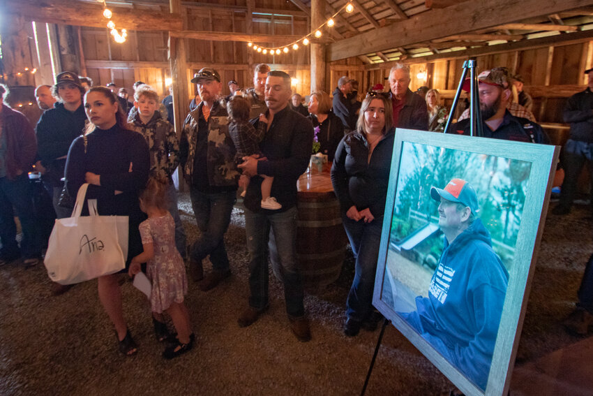 Attendees of the celebration of life for former Bucoda Mayor and assistant fire chief Rob Gordon stand inside the Riverbend Ranch's barn on Saturday, June 15.
