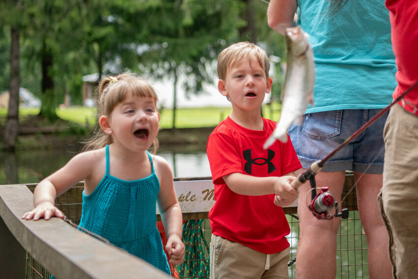 Neiyle and Nevaeh Eichhorn react to catching a trout at the Cole family pond in Chehalis on Saturday, June 8.