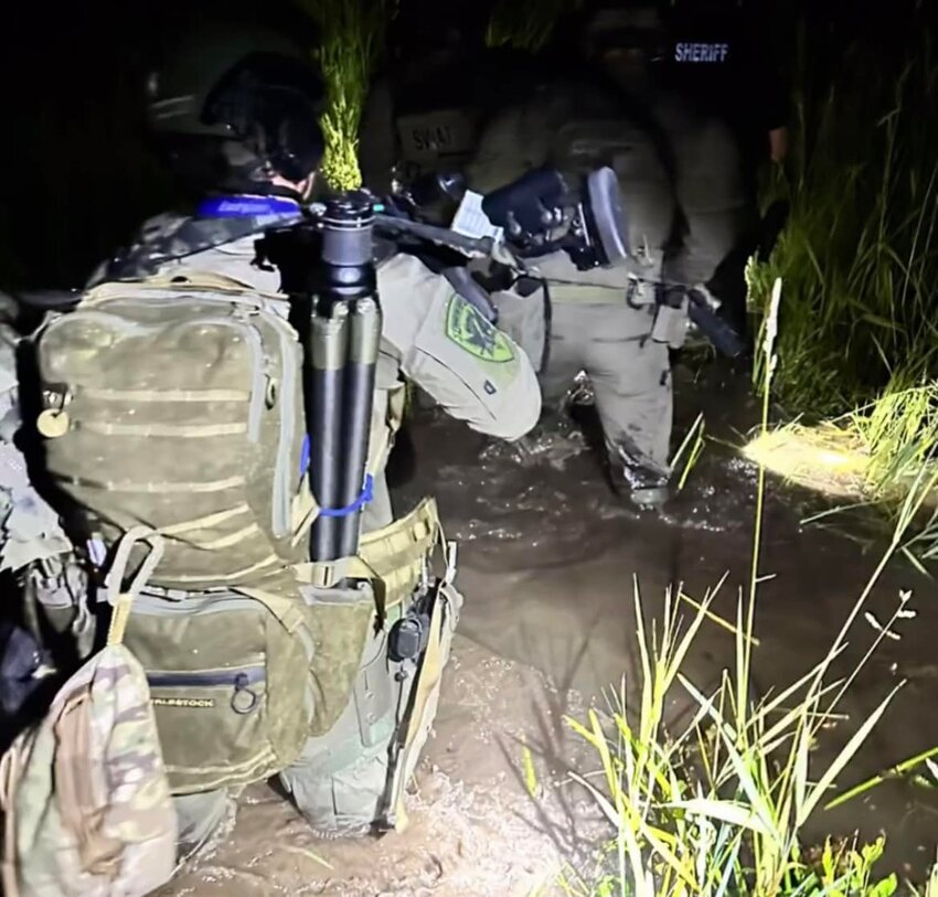 Authorities move through a marsh in the Billy Frank Jr. Nisqually National Wildlife Refuge overnight in pursuit of a suspect in a double-murder.