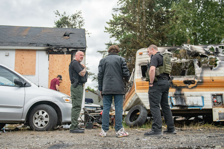 Detectives Mitch King, left, and Tim Odell of the Centralia Police Department interview the homeowner of a property that caught fire on the morning of Monday, June 24, on East Van Buren Street in Centralia.