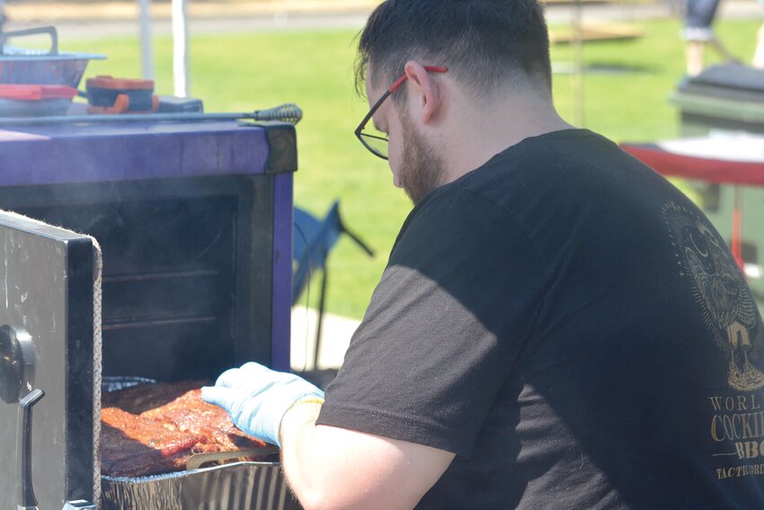 Cody Leslie, with Barbecue ICU, prepares smoked ribs for the Amateur Andy’s Competition on July 22, 2023, at the Nisqually Valley Barbecue Rally.