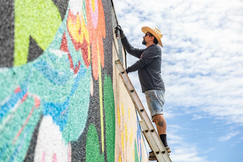Christian Barrios, of Vancouver, spray paints a mural on East Hanson Street in Centralia on Friday, June 28. Barrios, originally from Mexico City, was recruited by the Centralia Downtown Association to paint the mural.