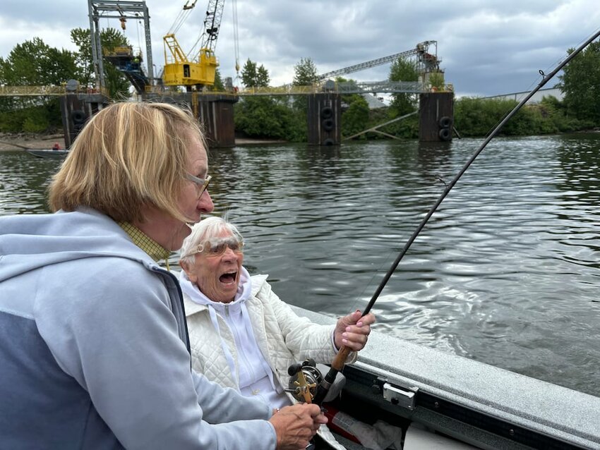 Even at 100-years-old Betsy Jeffords is both strong enough to hang on to a salmon-tugging rod and excited enough to scream with delight as her daughter, Susan Jeffords helps her reel.