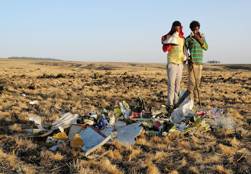 Two local boys examine a pile of twisted metal gathered by workers during the continuing recovery efforts at the crash site of Ethiopian Airlines flight ET302 on March 11, 2019, in Bishoftu, Ethiopia. Flight 302 was just six minutes into its flight to Nairobi, Kenya when it crashed, killing all 157 passengers and crew on board March 10. As a result of the crash, Ethiopia joined China and other countries in grounding their fleets of Boing 737 Max 8 jets. (Jemal Countess/Getty Images/TNS)