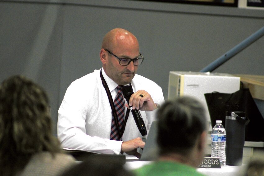 Yelm Community Schools Superintendent Chris Woods reads off the positions furloughed during the district's second round of reductions during its school board meeting at Ridgeline Middle School on May 23.