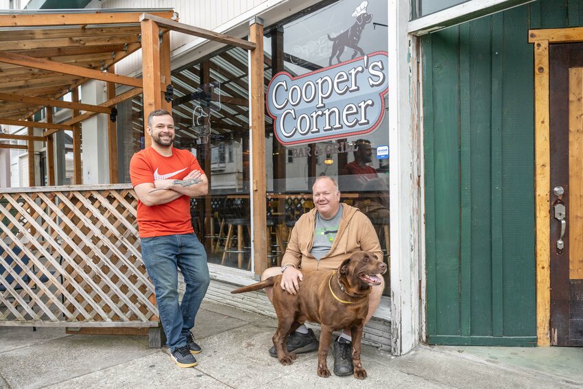 Chef Chris Madgett, left, and owner Dan Waller pose for a photo with Cooper outside of Cooper&rsquo;s Corner located at 289 NW Chehalis Ave. in Chehalis on Tuesday, July 2.