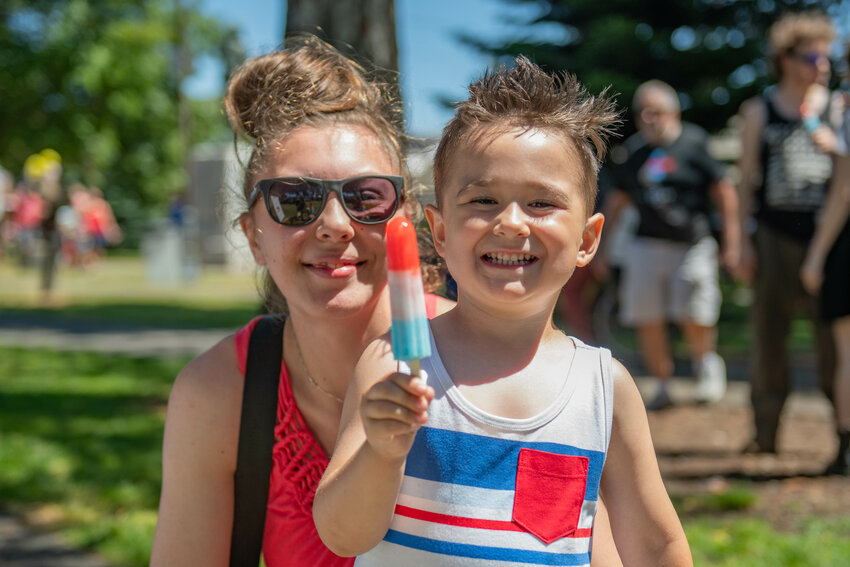 Teagan Bornstein-Cook smiles with a popsicle next to his mother Kayleigh at George Washington Park during Centralia's Annual Summerfest on July 4.