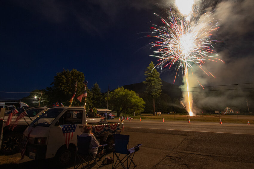 An East Lewis County resident sits next to a patriotically decorated truck on Saturday, July 6, during Packwood's Independence Day fireworks show.