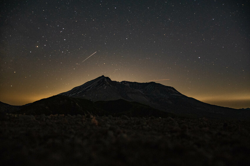 Stars shine over Mt. St. Helens as a shooting star, left, and airplane, right, pass by in this long exposure photo, taken from the top of Windy Ridge Viewpoint on Tuesday, July 9.