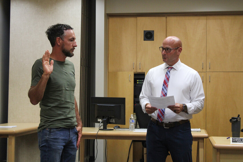 Yelm Community Schools Superintendent Chris Woods, right, swears Frank King, left, into the District No. 1 position on July 18.
