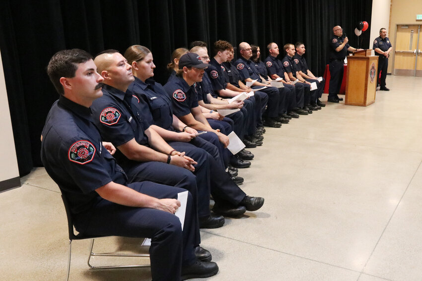 Riverside Fire Authority firefighters sit while Fire Chief Kevin Anderson and Assistant Chief of Operations and Training Erik Olson present during a badge pining ceremony at Centralia High School on Wednesday, July 17.
