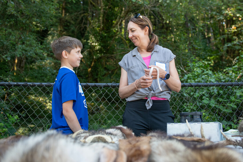 Wildlife biologist Jessica Homyack smiles with event attendee Brandon Dickey while talking about snakes during an &ldquo;Animals in Nature&rdquo; event at the Seminary Hill Natural Area on Saturday, July 20.