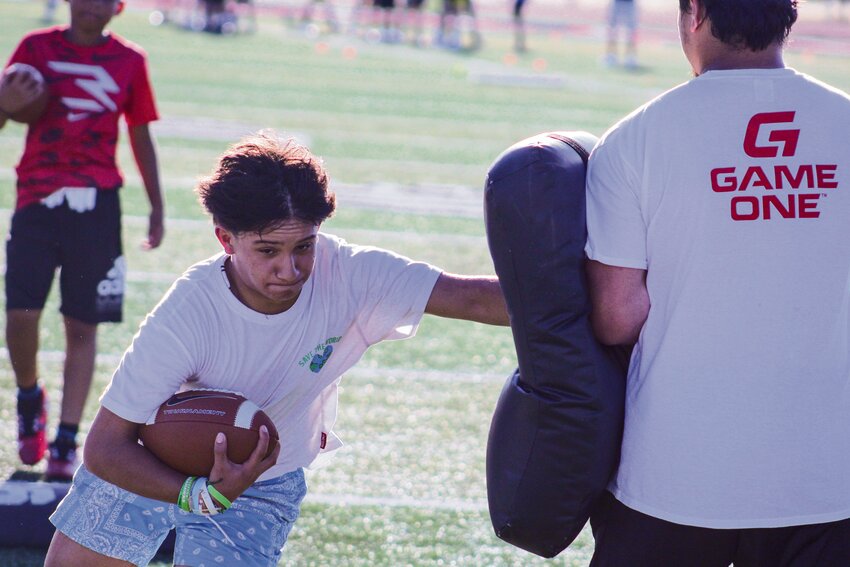 Kaliber Kile prepares to throw a pass during a quarterback drill at a Total Sports Development football skills clinic on July 16.