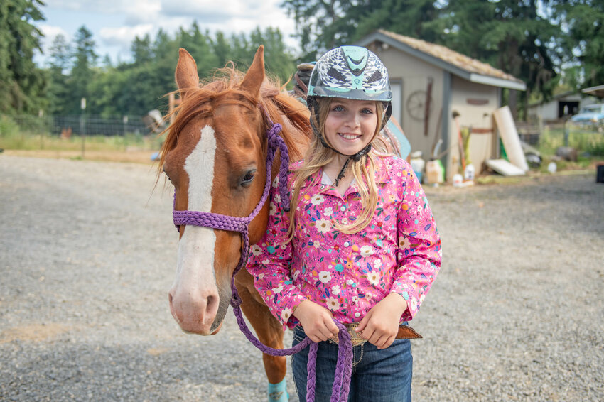 Paislee Miles smiles for a photo with her horse Romeo at their home in Onalaska on Thursday, July 25.