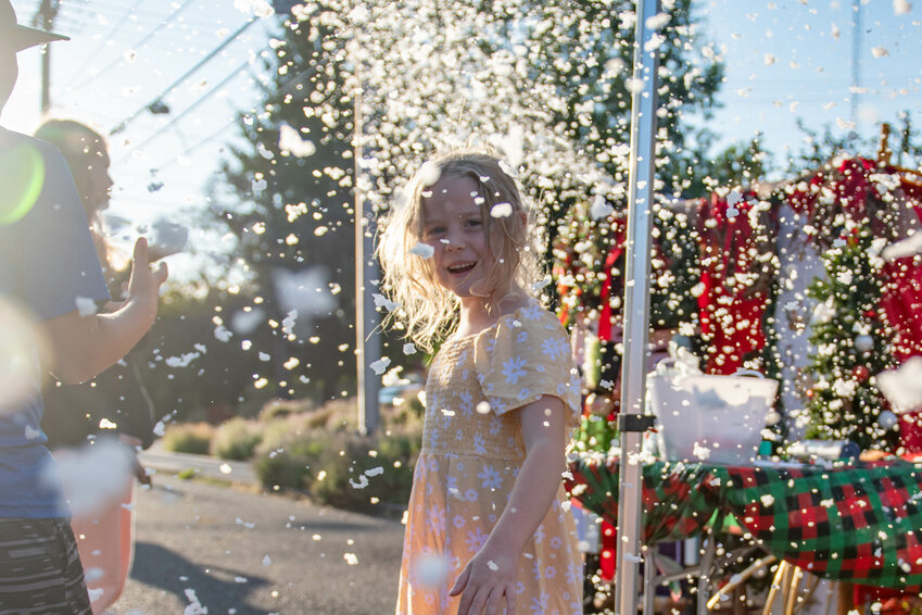 Poppy Moseley smiles as fake snow flurries at the Centralia Downtown Assosiation&rsquo;s Christmas In July Block Party on Wednesday, July 24.