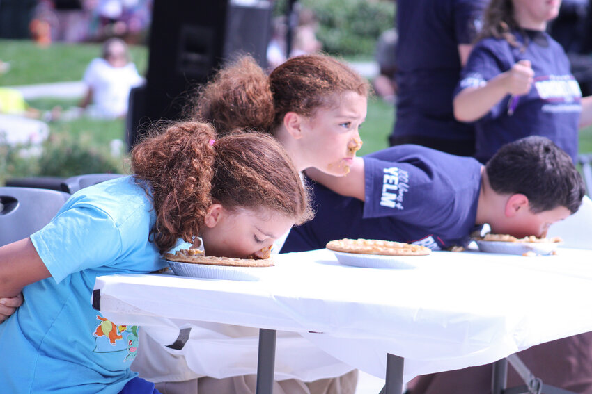 Three pie-eating contestants dive into their pumpkin pastries at the 2024 Nisqually Valley Barbecue Rally on July 27.