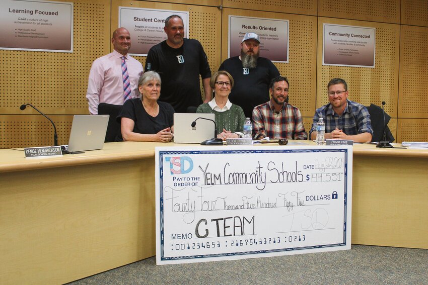 Yelm Community Schools Superintendent Chris Woods, the Board of Directors and representatives of Total Sports Development pose for a photo with a $44,551 check on Aug. 22.