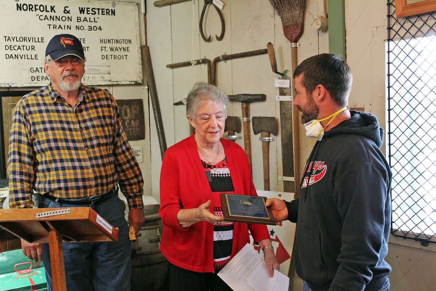 Charlie Hamilton, right, representing the family of the late Lloyd Deierling, presents the George C. Drake award Saturday to be hung at the Moberly Railroad Museum to Randolph County Historical Society President Joyce Cooper-Campbell. Deierling was to receive the award, which is the highest honor of the Wabash Railroad Historical Society, but he died earlier this year. The award initially was presented by Robert McNeill, left, president of the Wabash society, to Deierling's family.